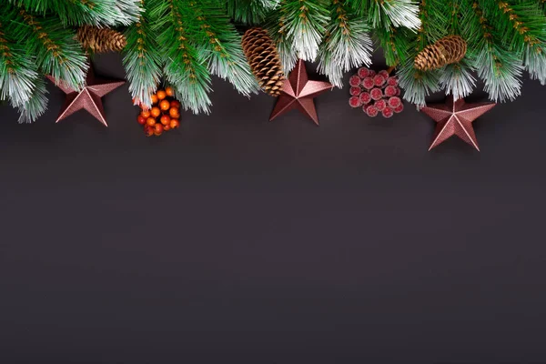 Composizione delle vacanze di Natale. Addobbi natalizi festivi, bagattelle, rami di abete, stella coriandoli su sfondo nero scuro con spazio copia. Mockup banner, cartolina. Posa piatta, vista dall'alto, sopraelevato — Foto Stock