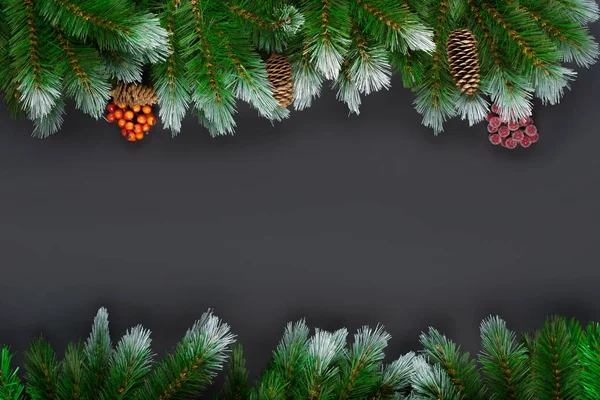 Decoração de Natal ou Ano Novo em fundo preto: ramos de abeto, bagas de inverno vermelhas com espaço de cópia. Mockup de banner, postal. Deitado plano, vista de cima, por cima. Vista superior com espaço de cópia. Falt lay — Fotografia de Stock