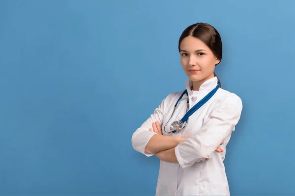 Mavi arka planda steteskopu olan beyaz üniformalı mutlu doktor kadın. — Stok fotoğraf