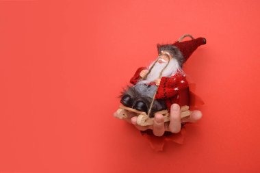  Kırık kırmızı kağıt duvarda kırmızı ve beyaz çizgili hediye kutusu var. Reklam ve teklif veya satış içeriğiniz için alanı bir kenara bırakın.