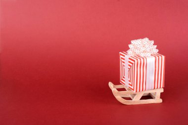 Noel ya da yeni yıl arkaplan tasarımı. Kış kızağı ve kırmızı arka planda hediye kutusu. Metin için alanı olan Noel arkaplanı