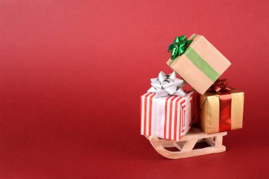 Noel ya da yeni yıl arkaplan tasarımı. Kış kızağı ve kırmızı arka planda hediye kutusu. Metin için alanı olan Noel arkaplanı.