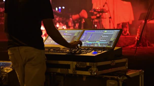 DJ configura luces de escenario con focos de discoteca. Las alfombras de DJs tuercen y sintonizan música y luces en el panel de control . — Vídeos de Stock