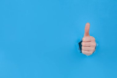 Sembolik onay jesti, yırtık mavi kağıt çarşaflar içinde onaylandı. Kazananın el hareketi, tamam el hareketi, onaylı el hareketi. Metin için boşluk