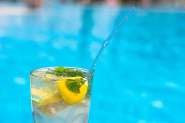 Yazın tatil köylerinin havuzunda taze Mojito kokteyli. Lüks tatil konsepti, metin için bir yer