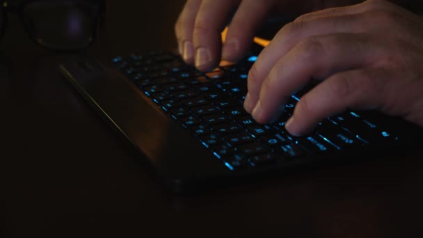 クローズアップLEDキーボード、男の手は青と赤の照明の光線でオフィスのLEDキーボードのコンピュータで動作します。事業概念. — ストック動画
