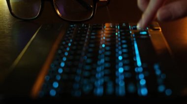 Ofisteki bilgisayarın önünde LED parlayan klavyede yakın plan kadın el yazısı. LED klavyenin arkasındaki bilgisayarda çalışan bir kız. Tablet bilgisayarda çalışan iş kadını.