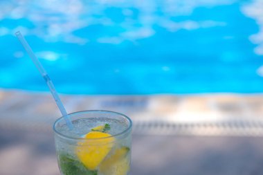 Yazın tatil köylerinin havuzunda taze Mojito kokteyli. Lüks tatil konsepti, metin için bir yer