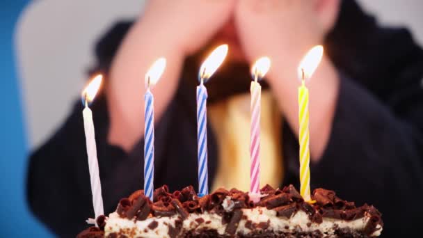 生日快乐男孩吹灭蜡烛在节日巧克力蛋糕在特写。生日或聚会的概念 — 图库视频影像
