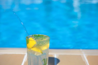 Yazın tatil köylerinin havuzunda taze Mojito kokteyli. Lüks tatil konsepti, metin için bir yer