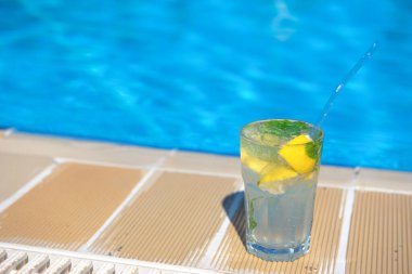 Yazın tatil köylerinin havuzunda taze Mojito kokteyli. Lüks tatil konsepti, metin için bir yer