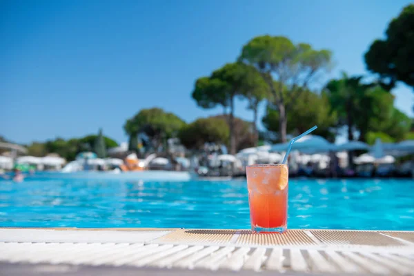 Bebidas alcohólicas frescas cóctel rojo sexo en la playa con hielo en vidrio en el borde de la piscina en el tiempo de verano contra el fondo lavado piscina y área de recreación. Concepto buenas vacaciones y viajes, lugar para el texto. —  Fotos de Stock