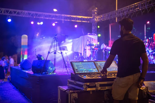Ses mühendisi ekibi müzik konseri sahnesine hazırlanıyor. Ses mikserini ayarlıyorum. Sahnelerin önündeki bir konserde DJ 'lik yapacak.