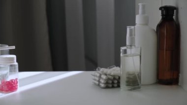 İlaç, vitamin, antibiyotik, antiseptik ve dezenfektanlı plastik şişelerle dolu ilk yardım çantasından oluşan arka duvar manzarası. Kırmızı haplar şeffaf şişede. Dolly kaydırma videosu.