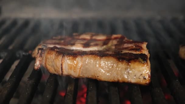 Carne de bife de carne é cozida sobre um fogo aberto com calor e fumaça de churrasqueira close-up. Dolly vídeo deslizante. — Vídeo de Stock