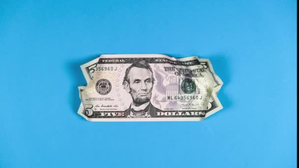 Animation Stop-Motion-Technik zerknüllt Papier fünf US-Dollar auf blauem Hintergrund. Konzept des Verfalls der amerikanischen Währung, Zusammenbruch der Börse und amerikanischer Aktien, Finanzkrise im Land — Stockvideo