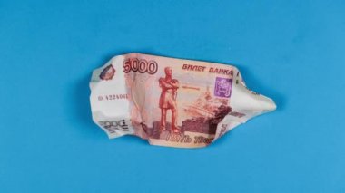 Kırışan kağıt animasyon tekniğini durdurun. Mavi üzerine beş bin Rus rublesi. Rus para biriminin çöküşü, çöküş borsası ve Rus hisseleri, ülkedeki mali kriz kavramı