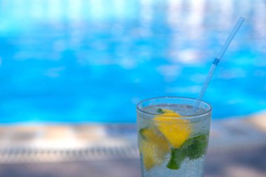 Yazın tatil köylerinin havuzunda taze Mojito kokteyli. Lüks tatil konsepti, metin için bir yer