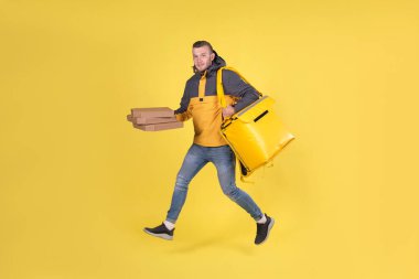 Sırtında termik torba olan sarı elbiseli sarışın ergen yemek dağıtım elemanı ve kurye müşteri siparişini tutuyor ve siparişi 15 dakika içinde ulaştırmak için koşuyor. Şehre yiyecek teslimatı