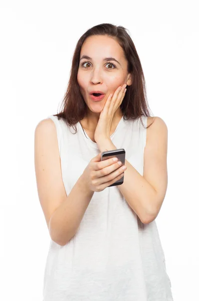 Astonished woman holding a smartphone — Stock Photo, Image