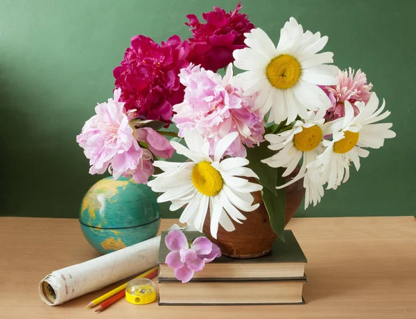 World Teacher\'s Day (still life with peony flowers bunch, books, map and globe on artistic background)