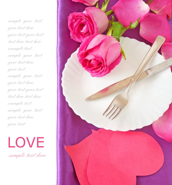 漂亮的粉红玫瑰和一个餐叉和刀在白色背景上的盘子 — 图库照片