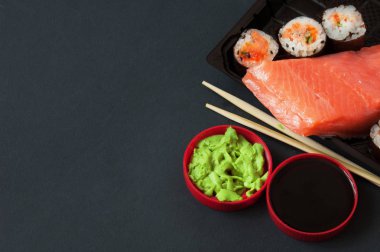 Suşi çeşitli siyah arka plan üzerine hizmet alır. Suşi paket servisi olan restoran kavramı