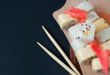 Suşi çeşitli siyah arka plan üzerine hizmet alır. Suşi paket servisi olan restoran kavramı