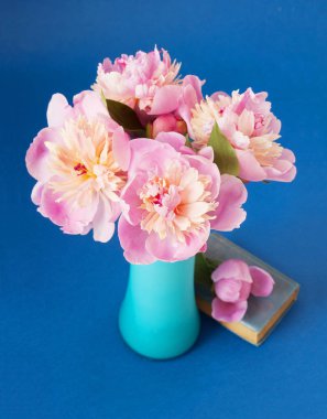 Pembe peonies ve resim arka plan üzerine açık kitap büyük grup ile natürmort