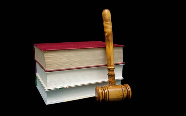 Libri e martelletto di un giudice in legno su sfondo nero — Foto Stock