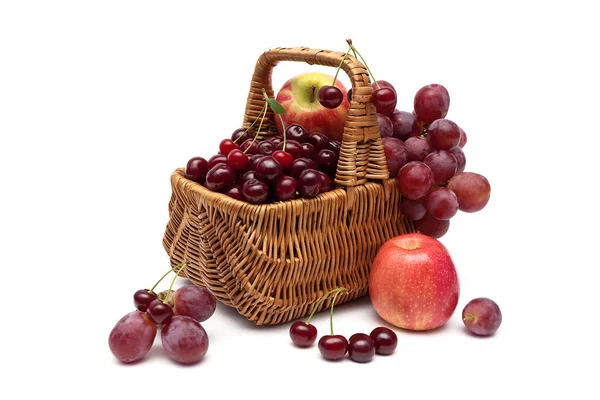 Cerises, raisins et pommes dans un panier sur fond blanc — Photo
