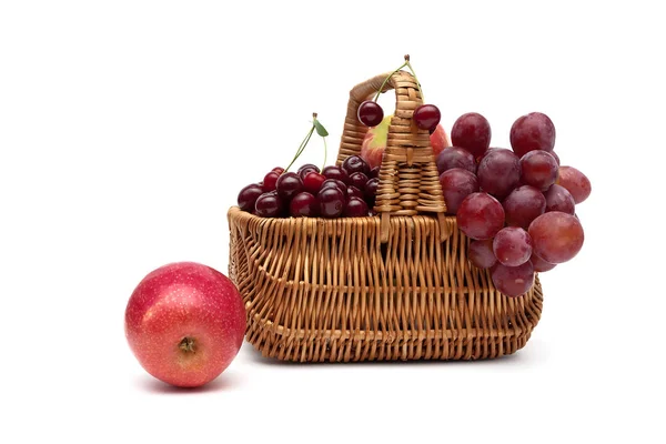 Frutta fresca in un cesto di vimini su sfondo bianco — Foto Stock