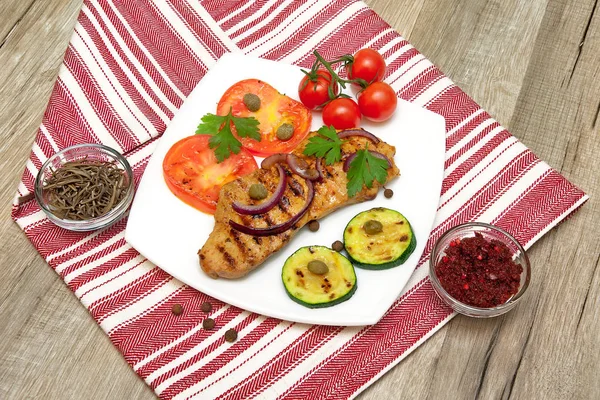 Filete a la parrilla con verduras en el plato sobre una mesa de madera — Foto de Stock