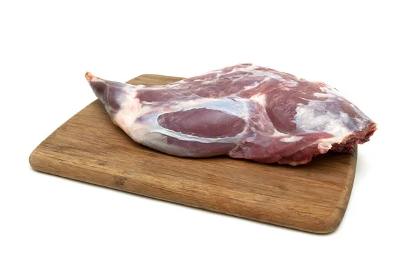 Raw leg of lamb on a cutting board isolated on a white backgroun — Stock Photo, Image