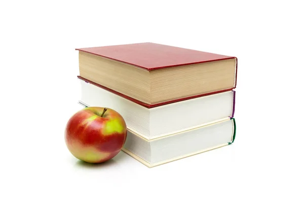 Libros y manzana madura sobre un fondo blanco —  Fotos de Stock