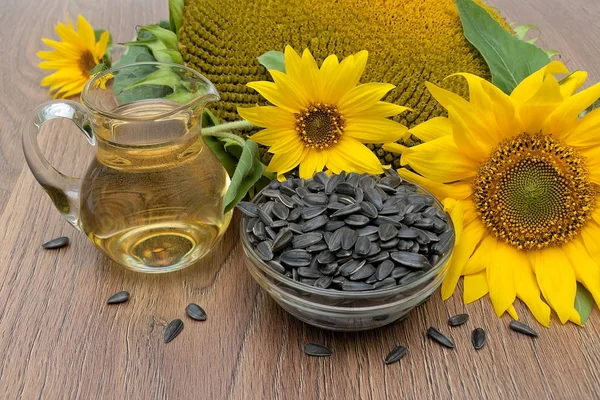 Sunflower, oil and seeds on a wooden background. — Stock Photo, Image