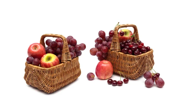 Kersen, druiven en appels in een mandje op een witte achtergrond — Stockfoto