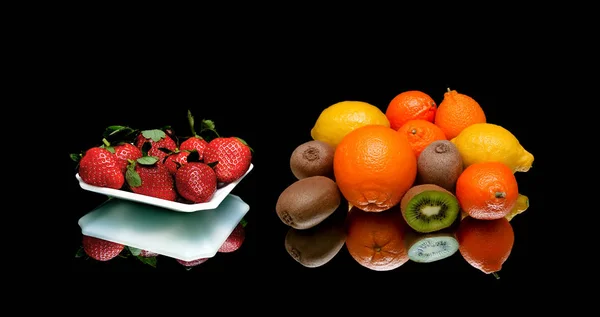 Strawberries and other fruits on a black background — Stock Photo, Image