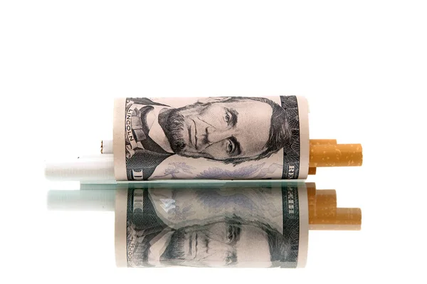 Drahý zlozvyk. peníze a cigarety na bílém pozadí — Stock fotografie