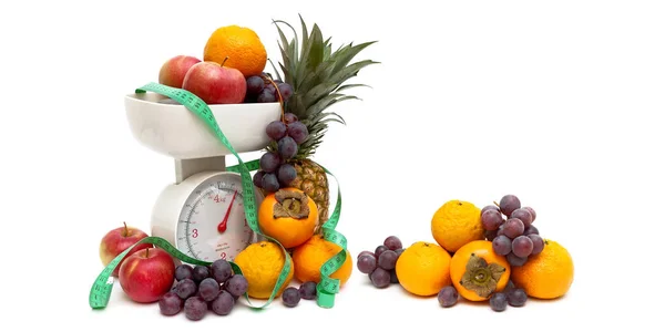 Kuchyňské váhy, ovoce a měřicí páska na bílém pozadí — Stock fotografie