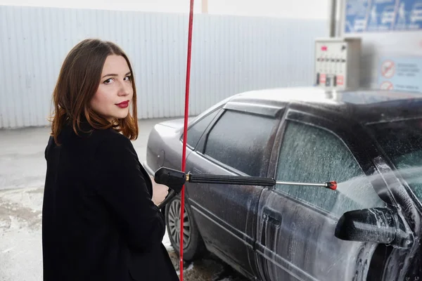 young girl washes the car