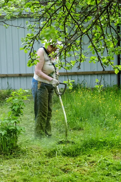 Grootmoeder maait het gras — Stockfoto