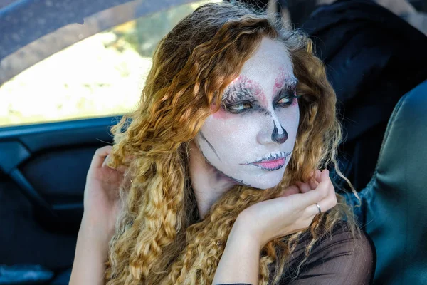 Zombie girl with black eyes and bloody mouth in the car — Stock Photo, Image