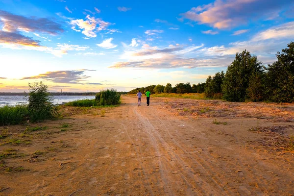 Dos personas corren a lo largo de la costa — Foto de Stock