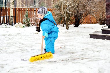 Çocuk evin yanında kar temizler