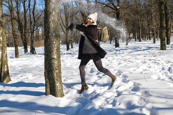 Молодая красивая девушка играет в снежки — стоковое фото