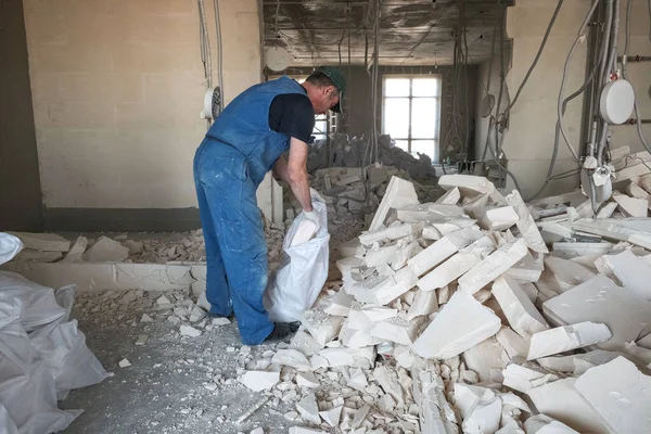 Arbeiter entfernt Trümmer von zerstörter Mauer — Stockfoto