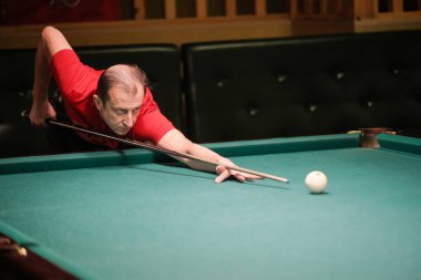 Oyuncu bilardoda topa nişan alıyor.
