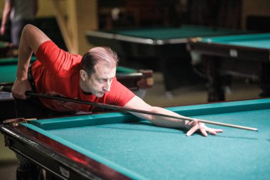 Oyuncu bilardoda topa nişan alıyor.