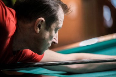 Oyuncu bilardoda topa nişan alıyor.